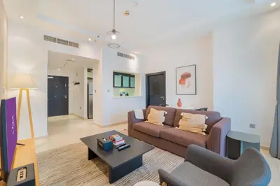 a living room with a couch and a table at SkyView Tower - Dubai Marina View - Lit Apartment in Dubai