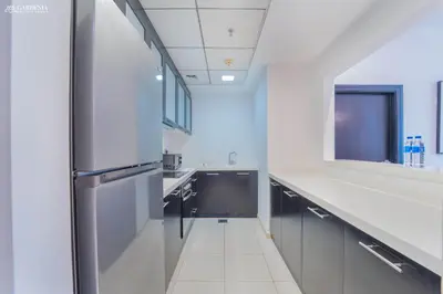 a large kitchen with a stainless steel refrigerator at SkyView Tower - Dubai Marina View - Lit Apartment in Dubai