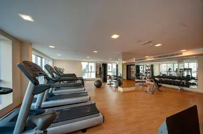a gym with treadmills and machines in a room at SkyView Tower - Dubai Marina View - Lit Apartment in Dubai