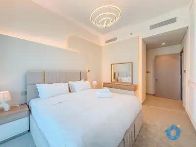 a bedroom with a large white bed and a mirror at Enjoy Best Burj Khalifa View from Balcony Next to Dubai Mall Luxury 2BR Like Home in Dubai