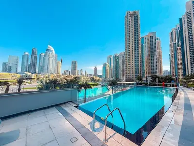 a swimming pool with a city skyline in the background at Enjoy Best Burj Khalifa View from Balcony Next to Dubai Mall Luxury 2BR Like Home in Dubai