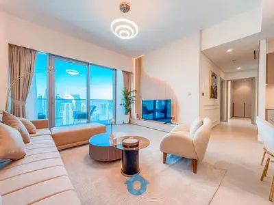 a living room with a couch and a large window at Enjoy Best Burj Khalifa View from Balcony Next to Dubai Mall Luxury 2BR Like Home in Dubai