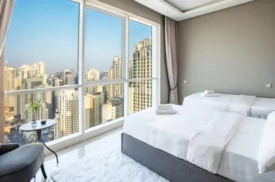 a bedroom with a large window with a city view at Lux 2BR Beachfront ap with icon Palm view in Dubai