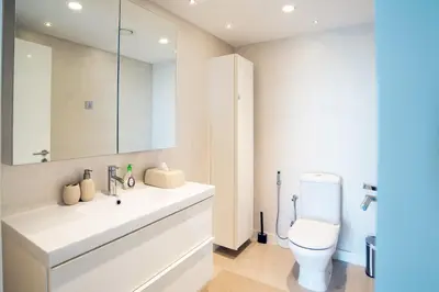 a bathroom with a white sink and a toilet at Lux 2BR Beachfront ap with icon Palm view in Dubai