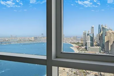 a view of the city from a window at Lux 2BR Beachfront ap with icon Palm view in Dubai