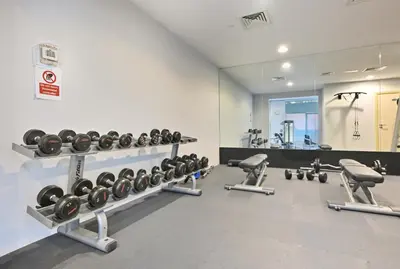 a gym with rows of dumbbells and a mirror at Lux 2BR Beachfront ap with icon Palm view in Dubai