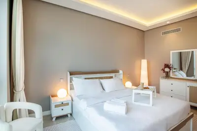 a bedroom with a large white bed and a mirror at Lux 2BR Beachfront ap with icon Palm view in Dubai