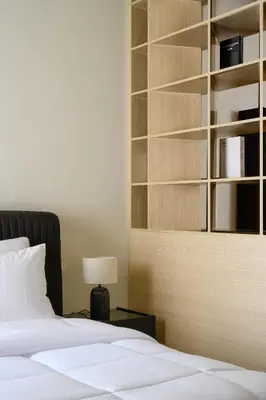 a bedroom with a bed and a book shelf at Stylish Studio Apartment in JVC in Dubai
