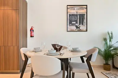 a dining room with a table and chairs and a picture at Stunning 1BR Luxury Downtown Burj View Balcony in Dubai