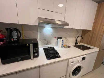 a kitchen with a microwave and a stove top oven at Captivating Studio in Jvc Elysee in Dubai