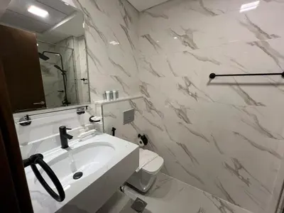 a white bathroom with a sink and a toilet at Captivating Studio in Jvc Elysee in Dubai