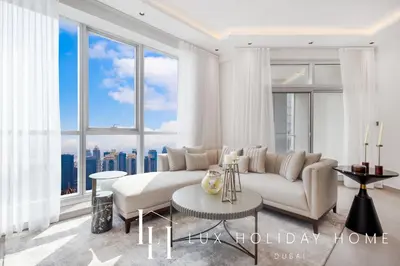 a living room with a white couch and a large window at LUX The Dubai Marina View Suite 3 in Dubai