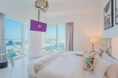 a white bedroom with a large bed and large windows at Damac Heights-Palm Jumeirah View-Elite Living in Dubai