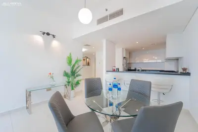 a dining room with a glass table and chairs at Damac Heights-Palm Jumeirah View-Elite Living in Dubai