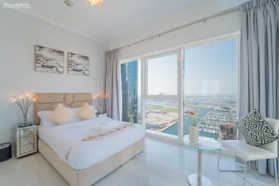 a bedroom with a bed and a large window at Damac Heights-Palm Jumeirah View-Elite Living in Dubai