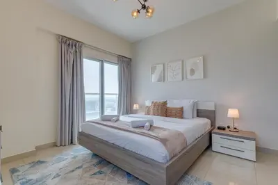 a bedroom with a large bed and a large window at Red Residence, Sports City - 2 Bedroom Apartment - Allsopp & Allsopp in Dubai