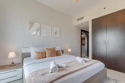 a white bedroom with a large bed with white sheets at Red Residence, Sports City - 2 Bedroom Apartment - Allsopp & Allsopp in Dubai