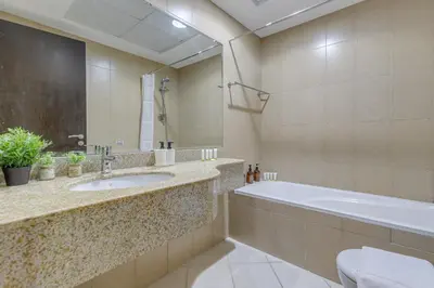 a bathroom with a tub and a sink and a bath tub at Red Residence, Sports City - 2 Bedroom Apartment - Allsopp & Allsopp in Dubai