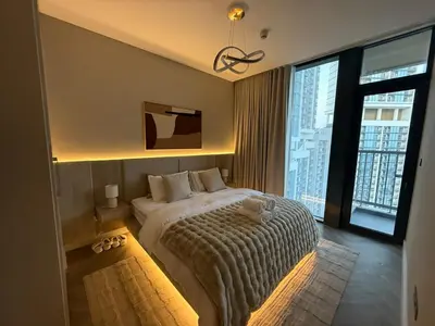 a bedroom with a large bed and a large window at Crest haven suite in Dubai
