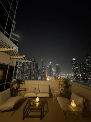 a balcony with couches and a city skyline at night at DT Penthouse • 250sqm • Billiards • Terrace & Pool in Dubai