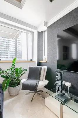 a living room with a chair and a tv at DT Penthouse • 250sqm • Billiards • Terrace & Pool in Dubai