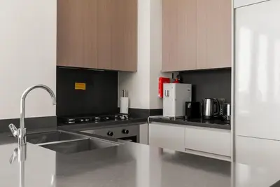a kitchen with a sink and a stove top oven at 3BR Ultra Luxury Waterfront Panoramic Views with Pool, Gym, Jacuzzi -10 mins to Burj Khalifa in Dubai