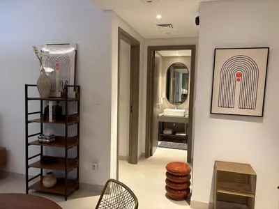 a bathroom with a mirror and a table and a chair at Stylish 1BR in CityWalk, Stunning Burj Khalifa view in Dubai