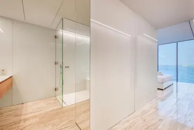 a bathroom with white walls and a glass shower at Luxury Apartment at Muraba Residence in Dubai