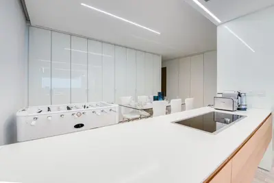 a large white room with a counter and chairs at Luxury Apartment at Muraba Residence in Dubai