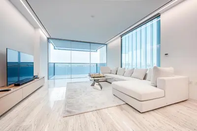 a living room with white furniture and large windows at Luxury Apartment at Muraba Residence in Dubai