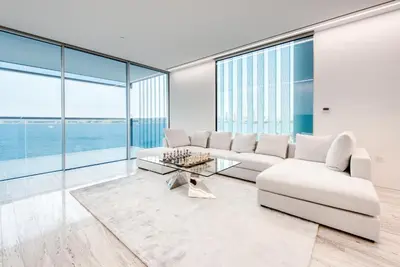 a living room with white furniture and large windows at Luxury Apartment at Muraba Residence in Dubai