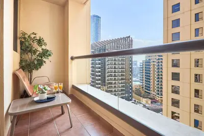 a balcony with a table and a view of a city at Family Stay JBR 3BR and maids room l Walk to Beach l Marina in Dubai