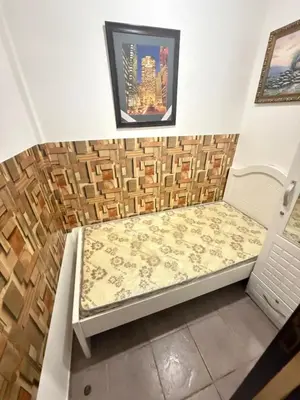 a bed in a room with two pictures on the wall at Cool valley homes in Dubai