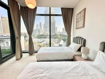 a hotel room with two beds and a large window at Luxury 2BR with Full Burj Khalifa View in Dubai