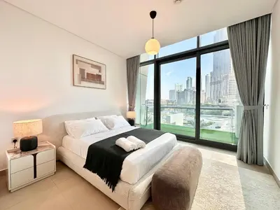 a bedroom with a bed and a large window at Luxury 2BR with Full Burj Khalifa View in Dubai