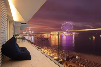 a view of a ferris wheel at night from a building at Luxurious 4BR La Vie JBR Private Beach Pool Panoramic Sea and Dubai Eye Views Drone Show Perfect for Family and Friends in Dubai