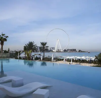 a large swimming pool with a ferris wheel in the background at Luxurious 4BR La Vie JBR Private Beach Pool Panoramic Sea and Dubai Eye Views Drone Show Perfect for Family and Friends in Dubai