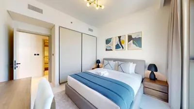 a white bedroom with a bed and a table at Vacationer l Stunning 1 Bed l Sea View l Private Beach Access in Dubai