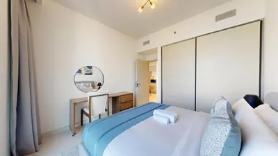 a bedroom with a bed and a desk and a mirror at Vacationer l Stunning 1 Bed l Sea View l Private Beach Access in Dubai