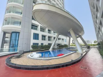 a building with a swimming pool in front of a building at Vacationer l Elegant 1 Bedroom l Arjan l Pool with View Deck in Dubai