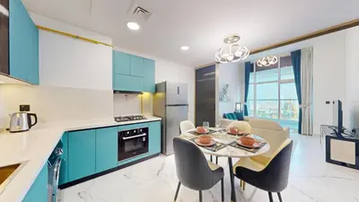 a kitchen with blue cabinets and a table and chairs at Vacationer l Elegant 1 Bedroom l Arjan l Pool with View Deck in Dubai