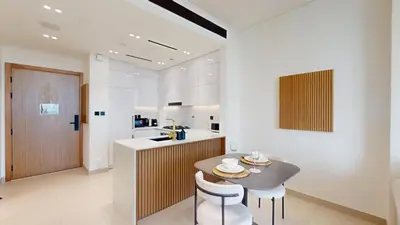 a kitchen with a table and two chairs and a counter at Vacationer l Contemporary 1 Bed l City Views l near Circle Mall in Dubai