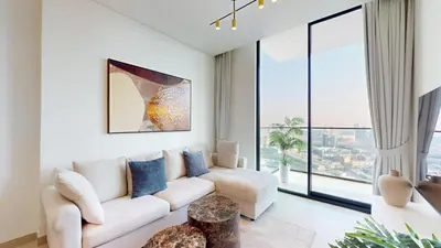 a living room with a white couch and a large window at Vacationer l Contemporary 1 Bed l City Views l near Circle Mall in Dubai
