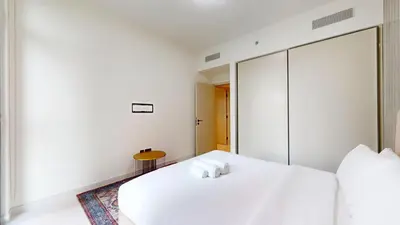 a white bedroom with two white beds and a table at Vacationer l Classic 2 Bedroom l Marina Views l Private Beach in Dubai