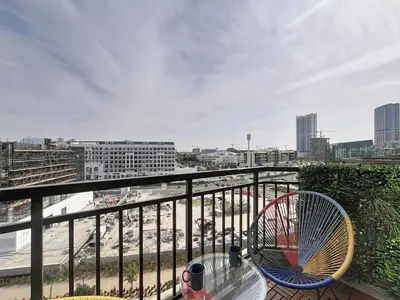 a balcony with a table and a fan on it at Vacationer I Modern Studio I Pool & Gym Access I 5-min Drive to Miracle Garden I Arjan in Dubai