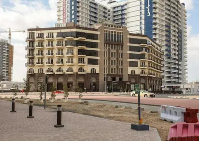 a large building in a city with tall buildings at Vacationer I Modern Studio I Pool & Gym Access I 5-min Drive to Miracle Garden I Arjan in Dubai