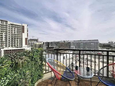 a balcony with two chairs and a table on it at Vacationer I Modern Studio I Pool & Gym Access I 5-min Drive to Miracle Garden I Arjan in Dubai