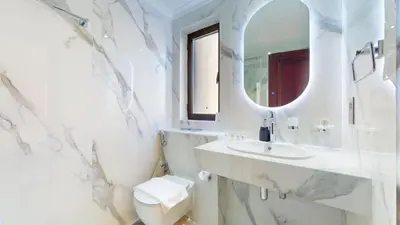 a white bathroom with a sink and a mirror at Vacationer l Upgraded Modern 2 Bed l Downtown l Near Dubai Mall in Dubai