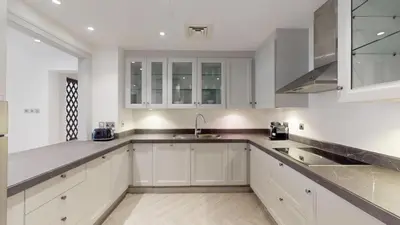 a kitchen with white cabinets and a sink at Vacationer l Upgraded Modern 2 Bed l Downtown l Near Dubai Mall in Dubai