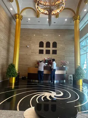 two people standing at a counter in a hotel lobby at Spacious 1 Bedroom Apartment-Opal Tower Dubai Marina in Dubai